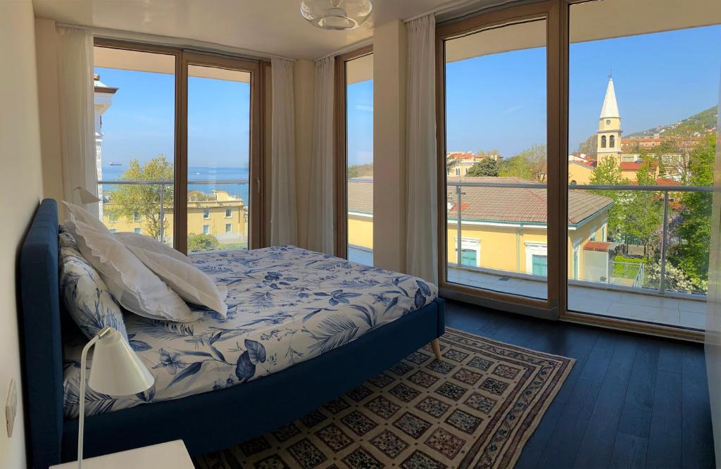 a bedroom with a bed with a view of the ocean at Panorama Apartment in Trieste