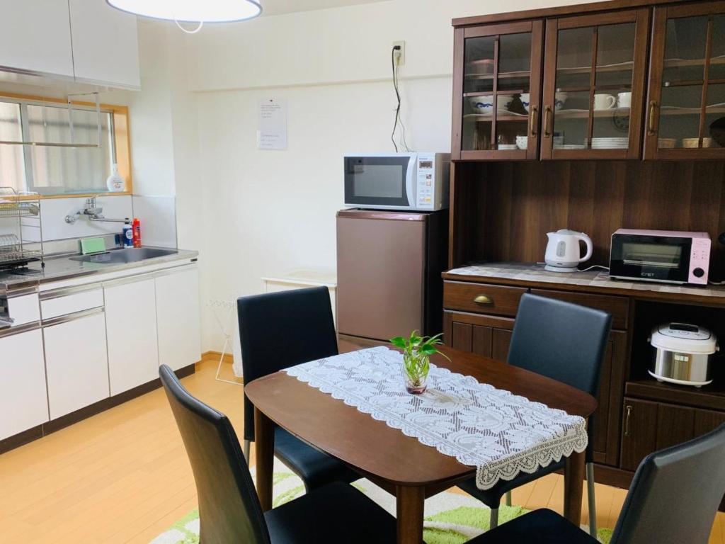 uma cozinha com mesa e cadeiras num quarto em K&M Heights - Vacation STAY 32213v em Tóquio