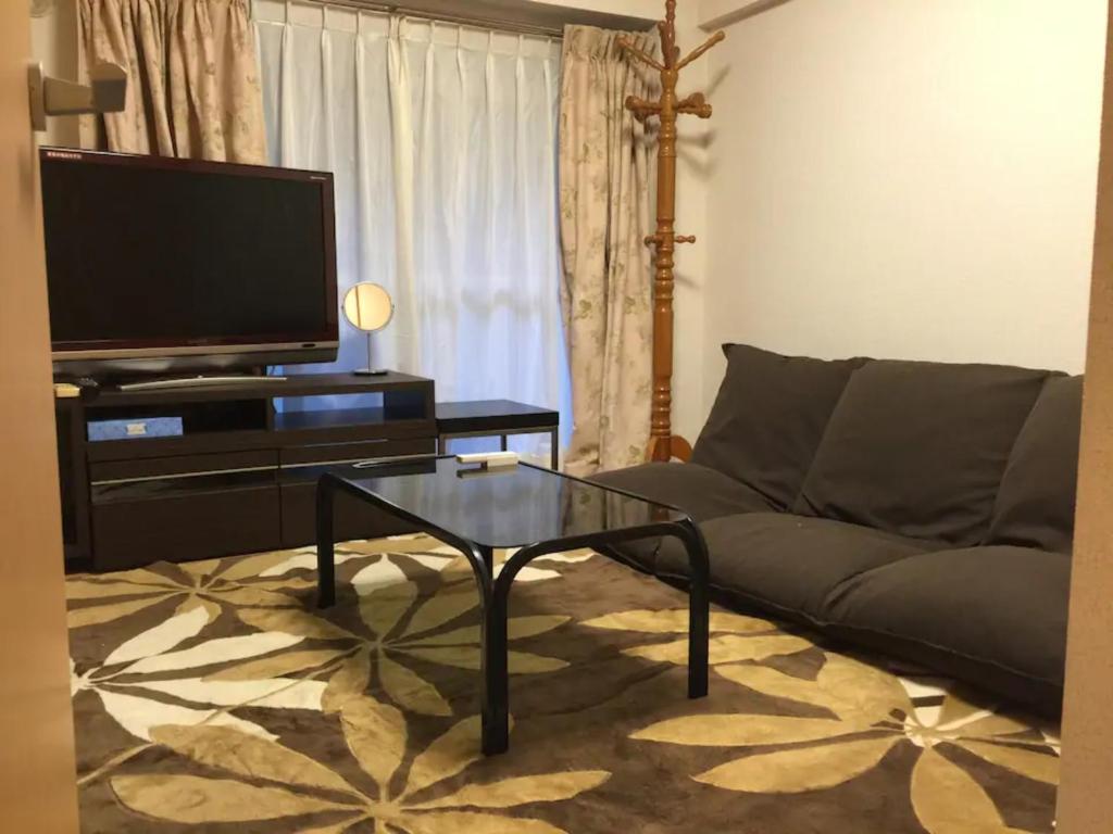 uma sala de estar com um sofá e uma mesa de centro em K&M Heights - Vacation STAY 32224v em Tóquio
