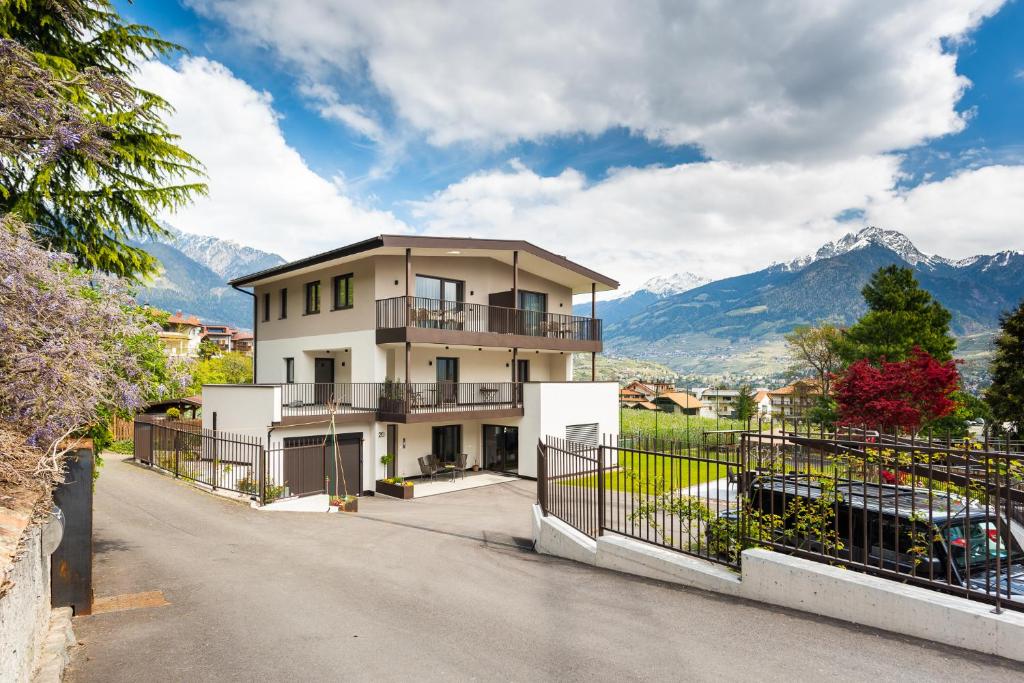 a house with a balcony and mountains in the background at Marlingsuites in Marlengo
