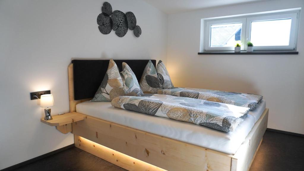 una camera da letto con letto con struttura in legno e finestra di Sky Appartement a Grosskirchheim