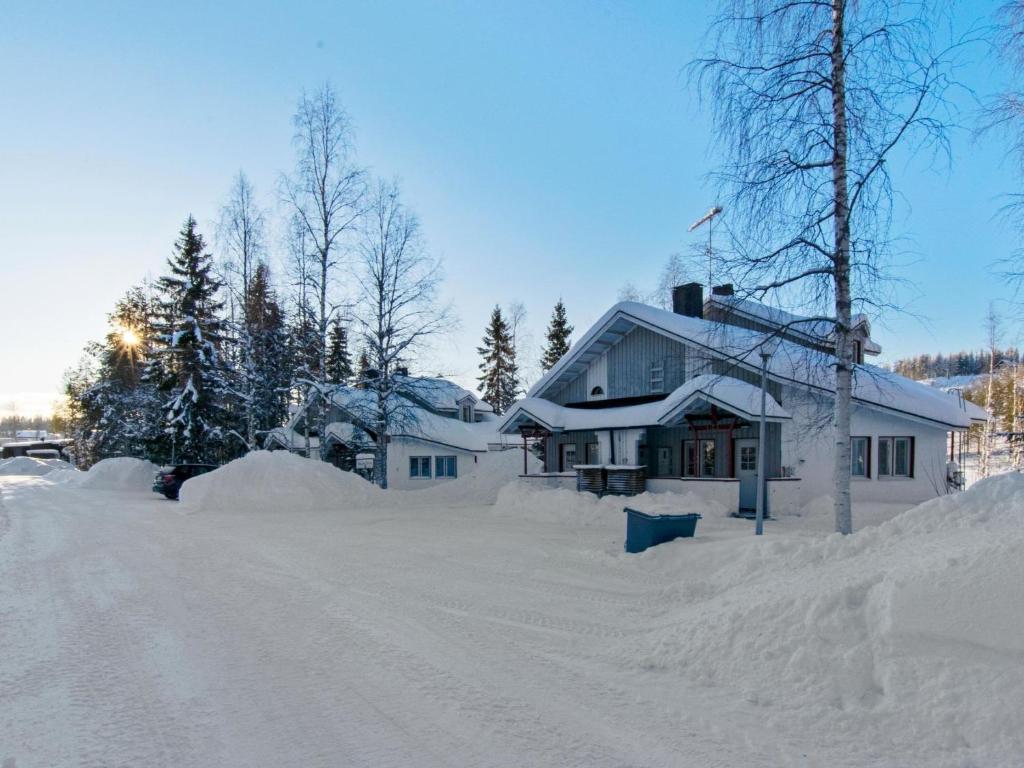 a house covered in snow in front of a road at Holiday Home Hallantytär b3 paritalo by Interhome in Hyrynsalmi