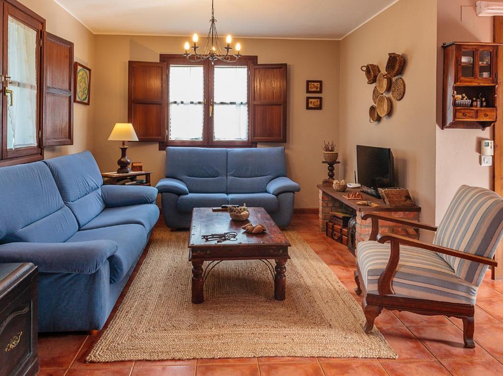 Sala de estar con sofás azules y mesa de centro en Casa Rural Ablanos de Aymar, en Loroñe