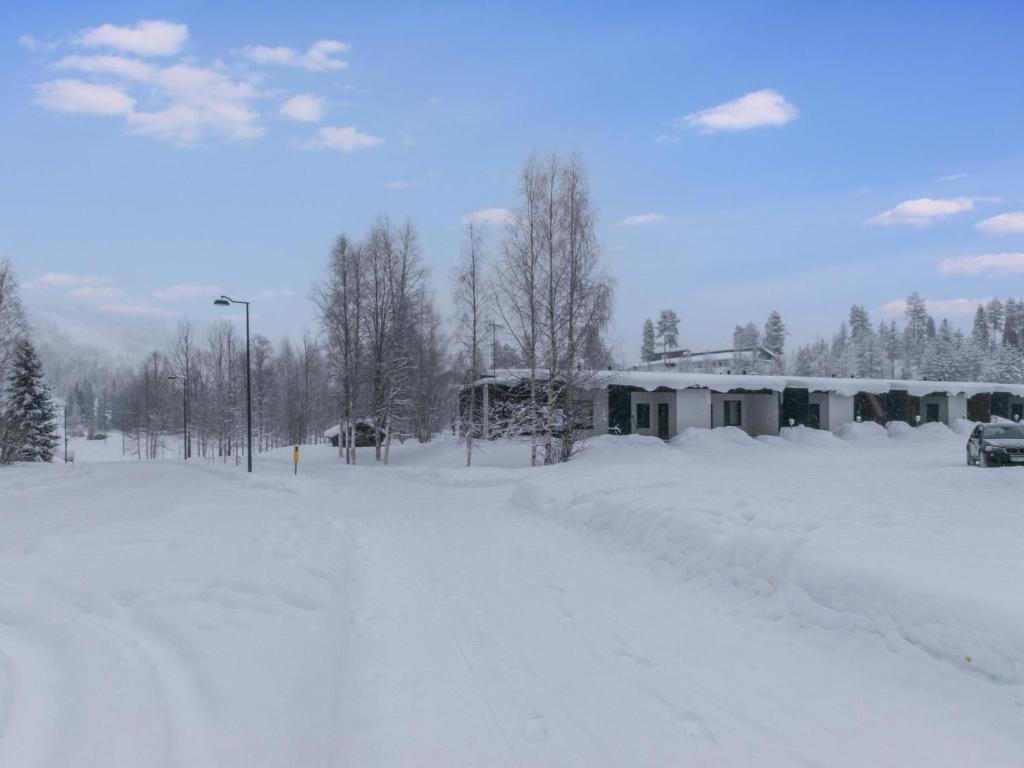 a snow covered street in front of a house at Holiday Home Skivillas paljakka 1- - 3 bedroom by Interhome in Kotila