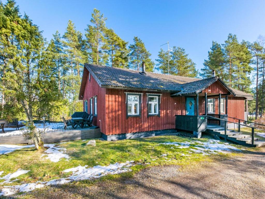 uma pequena casa vermelha na floresta com árvores em Holiday Home Villa nytorp by Interhome em Stormälö