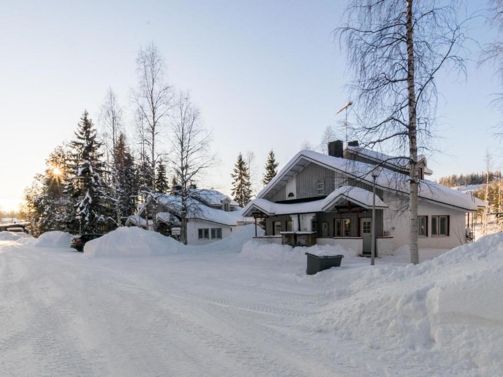 dom pokryty śniegiem, drzewami i drogą w obiekcie Holiday Home Hallantytär b4 paritalo by Interhome w mieście Hyrynsalmi