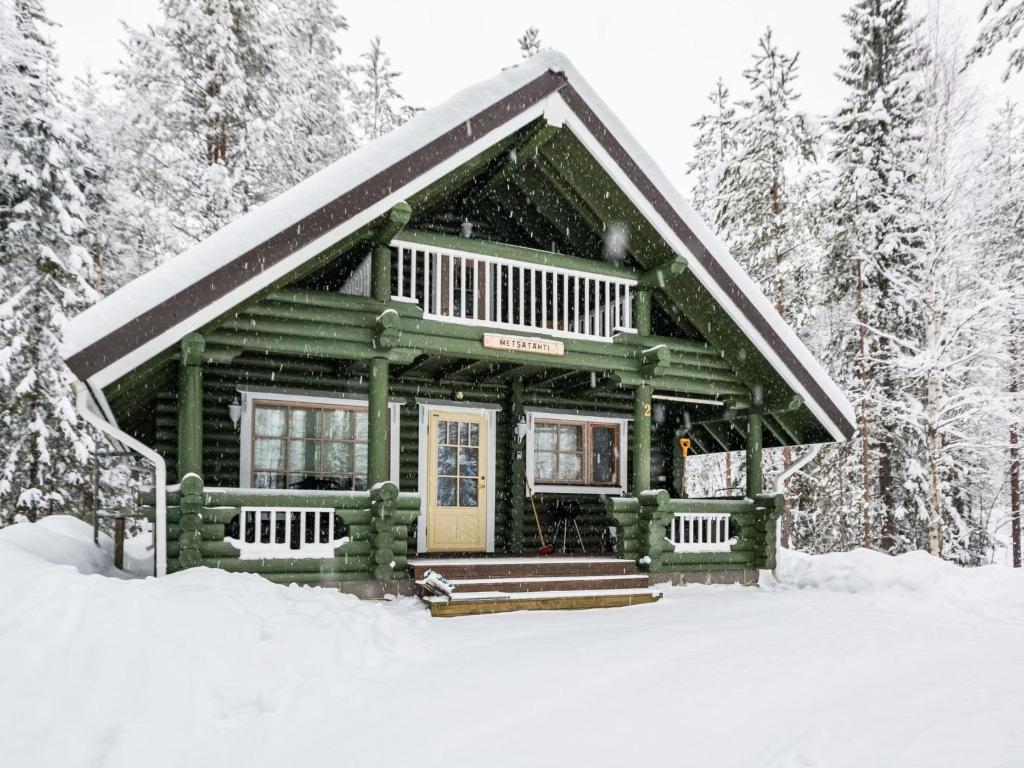 domek z bali w śniegu w lesie w obiekcie Holiday Home Metsätähti by Interhome w mieście Kotila