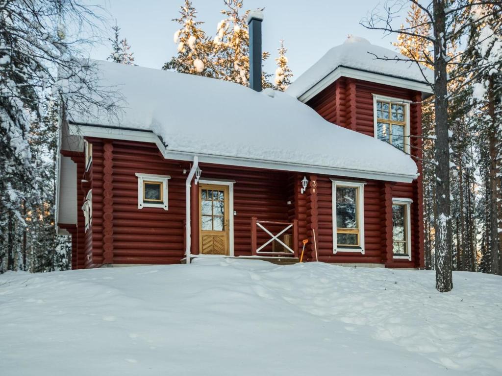 una cabaña de madera en la nieve en el bosque en Holiday Home Sateenkaari cottage by Interhome en Hyrynsalmi