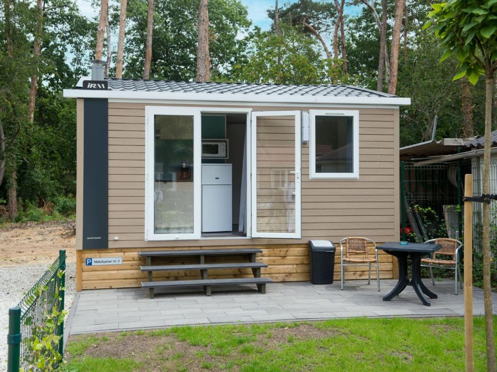 a tiny house with a bench and a table at Holiday Home De Brenkberg-1 by Interhome in Schinveld