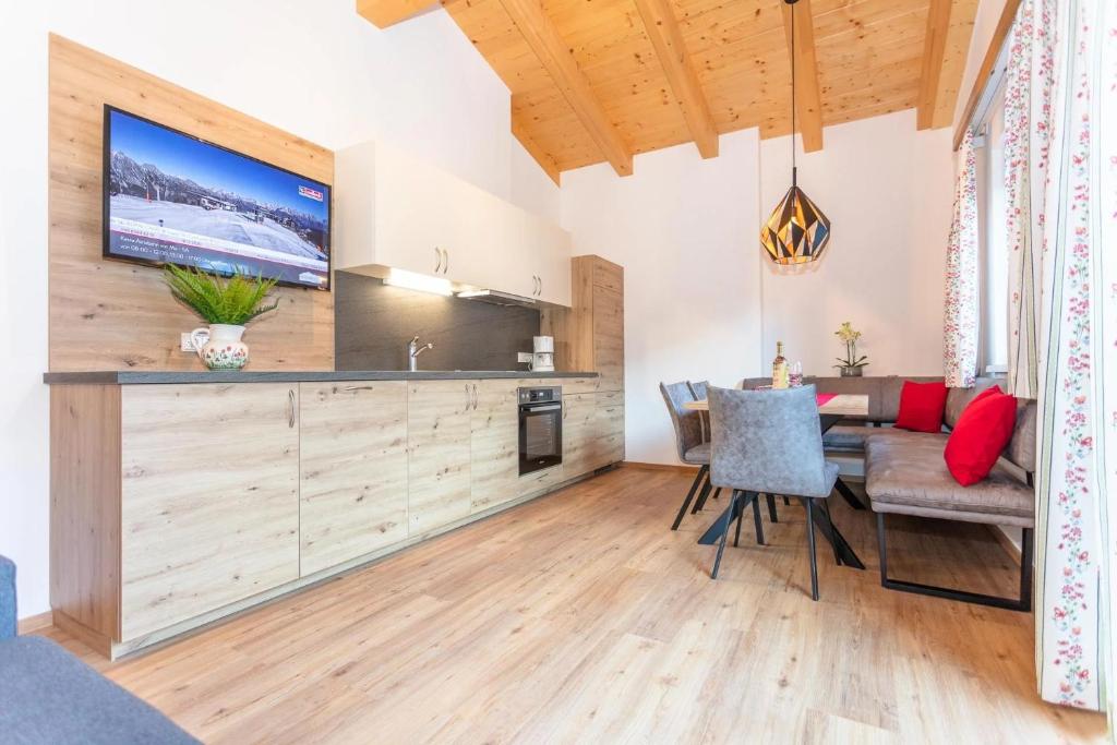 uma cozinha e sala de jantar com uma mesa e uma televisão em Ferienhaus Monika em Leogang