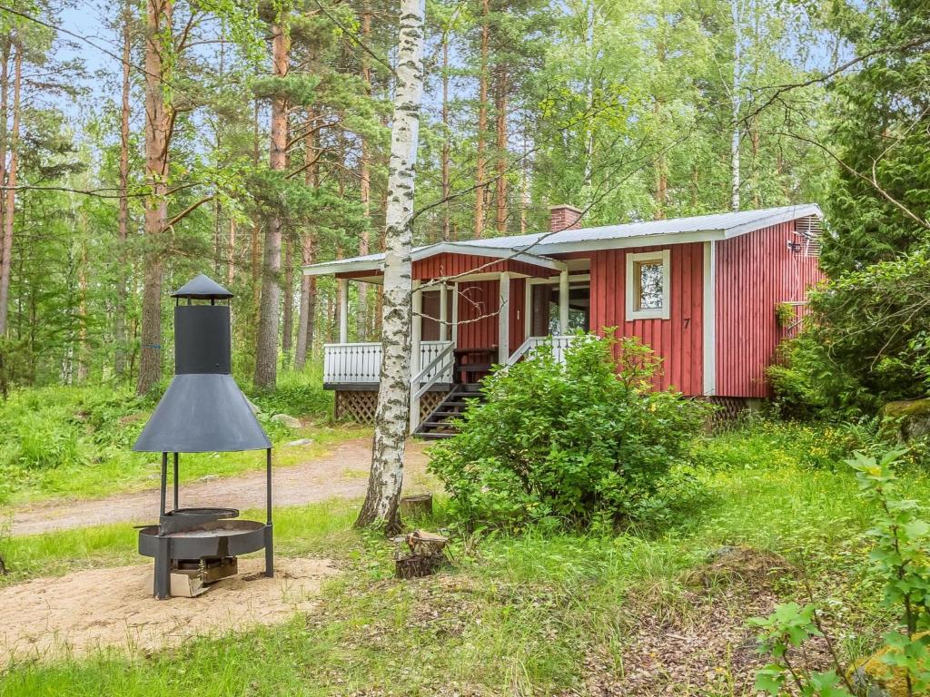a red tiny house in the woods with a lamp at Holiday Home Ahven by Interhome in Hiukkajoki