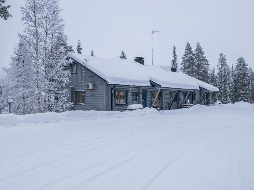 KotilaにあるHoliday Home Karhunpesä c by Interhomeの雪道の横に雪で覆われた家