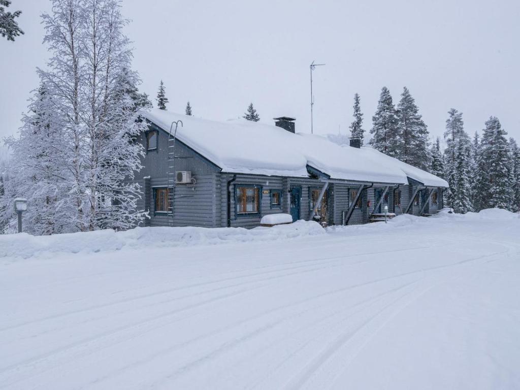 ein schneebedecktes Haus neben einer schneebedeckten Straße in der Unterkunft Holiday Home Karhunpesä c by Interhome in Kotila