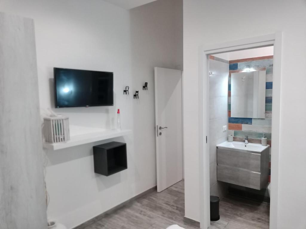 baño con lavabo y TV en la pared en Casa vacanze Tre stelle, en Termoli