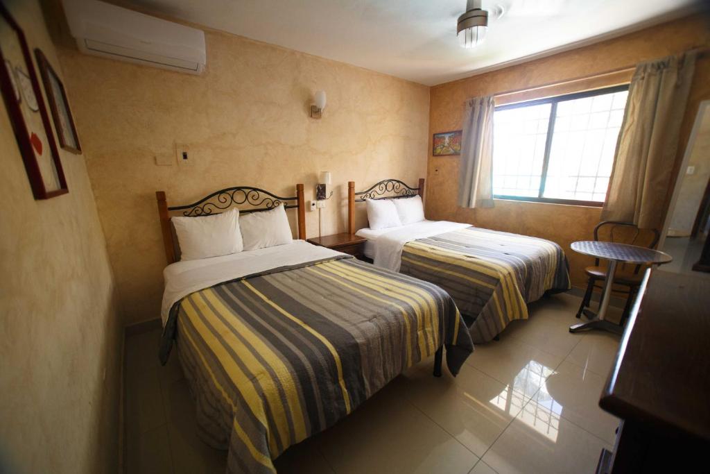 Cette chambre comprend 2 lits et une fenêtre. dans l'établissement Hotel La Casona Real, à Cozumel