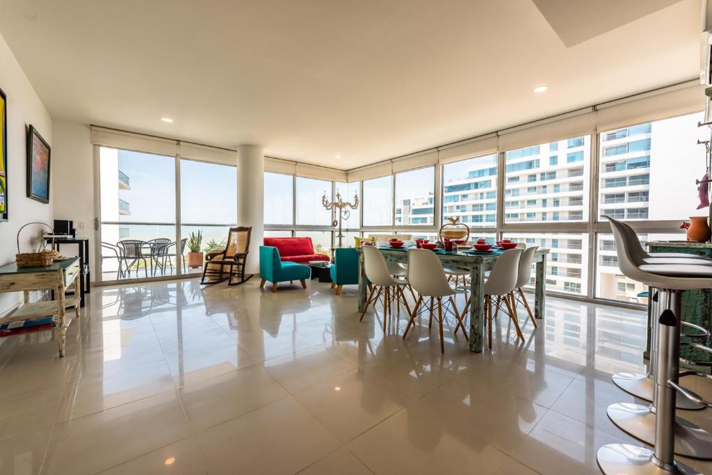 Un comedor y una sala de estar con mesa y sillas. en Edificio Morros Vitri Lujo con Panorama, en Cartagena de Indias