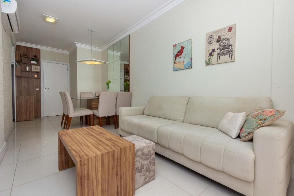 a living room with a couch and a table at Riomaggiore 201 -Lindo apartamento 200m da Praia de Bombas - Excelente Custo Benefício in Bombas