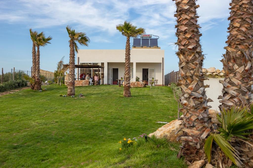 a house with palm trees in the yard at Marezè in Punta Secca