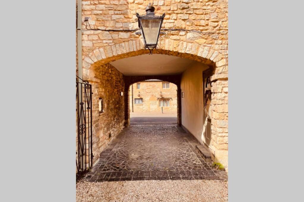 an alleyway in a stone building with a street light at Over The Arches, Chipping Campden in Chipping Campden