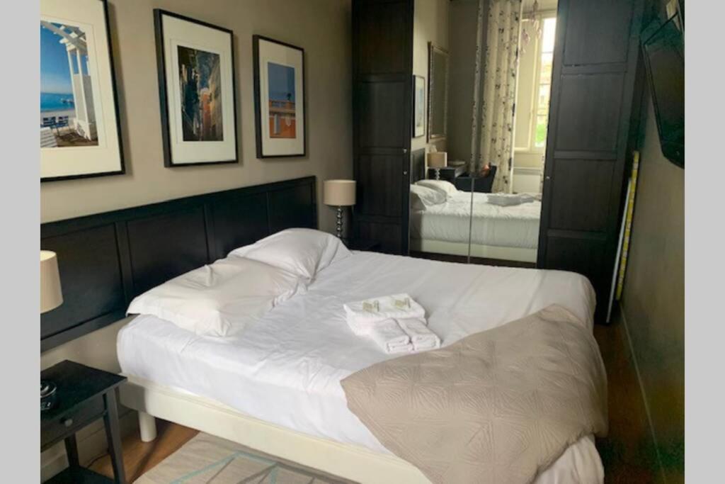 une chambre avec un lit blanc et un miroir dans l'établissement 18 Garibaldi, à Nice