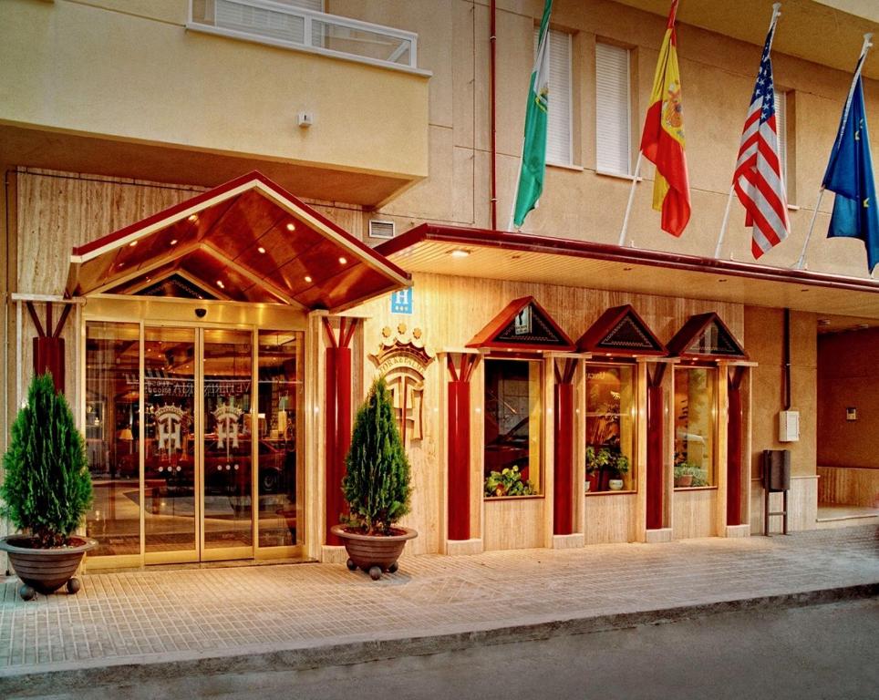 un front de magasin avec deux arbres en pot devant lui dans l'établissement Hotel Torrepalma, à Alcalá la Real