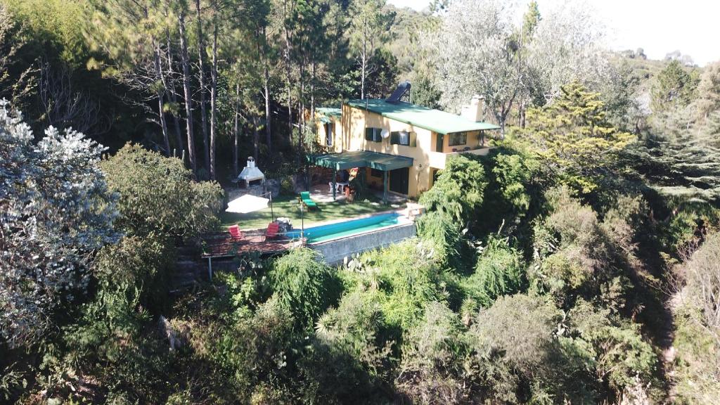 a house in the middle of a forest with a pool at Rancho Taxco in El Pueblito