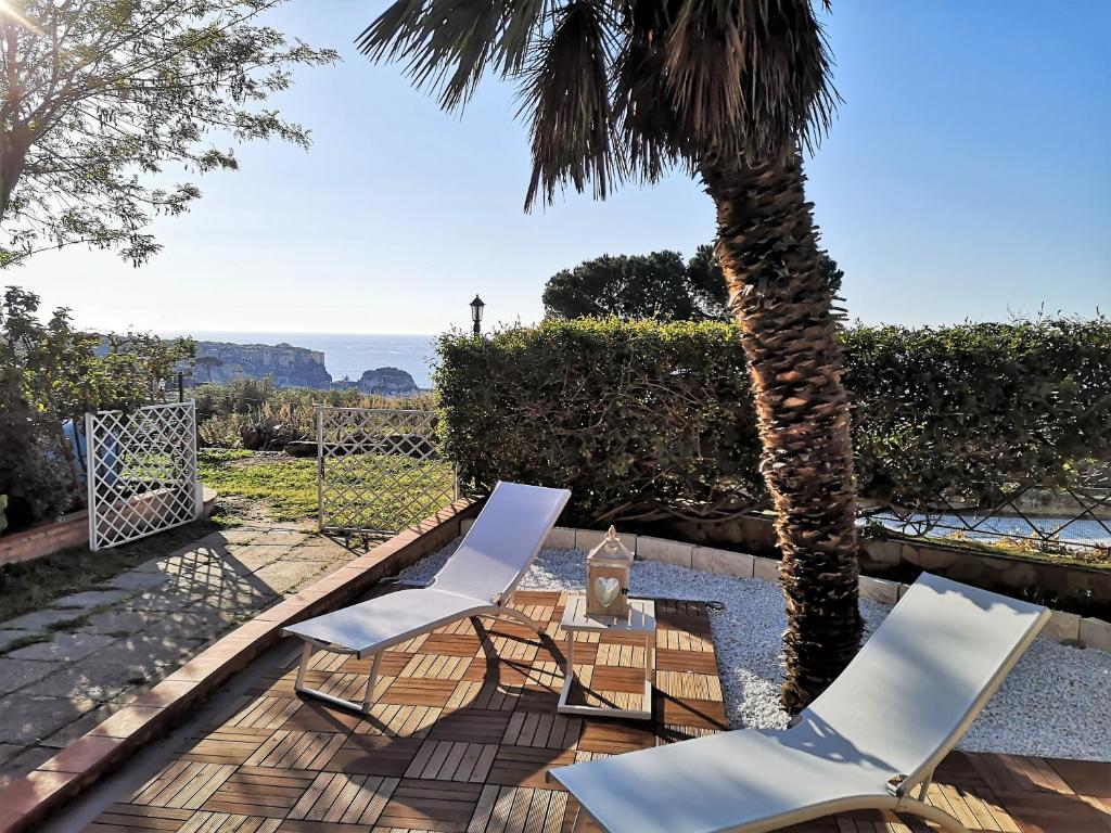 dos sillas y una mesa y una palmera en Il Pastore Serafino, en Tropea