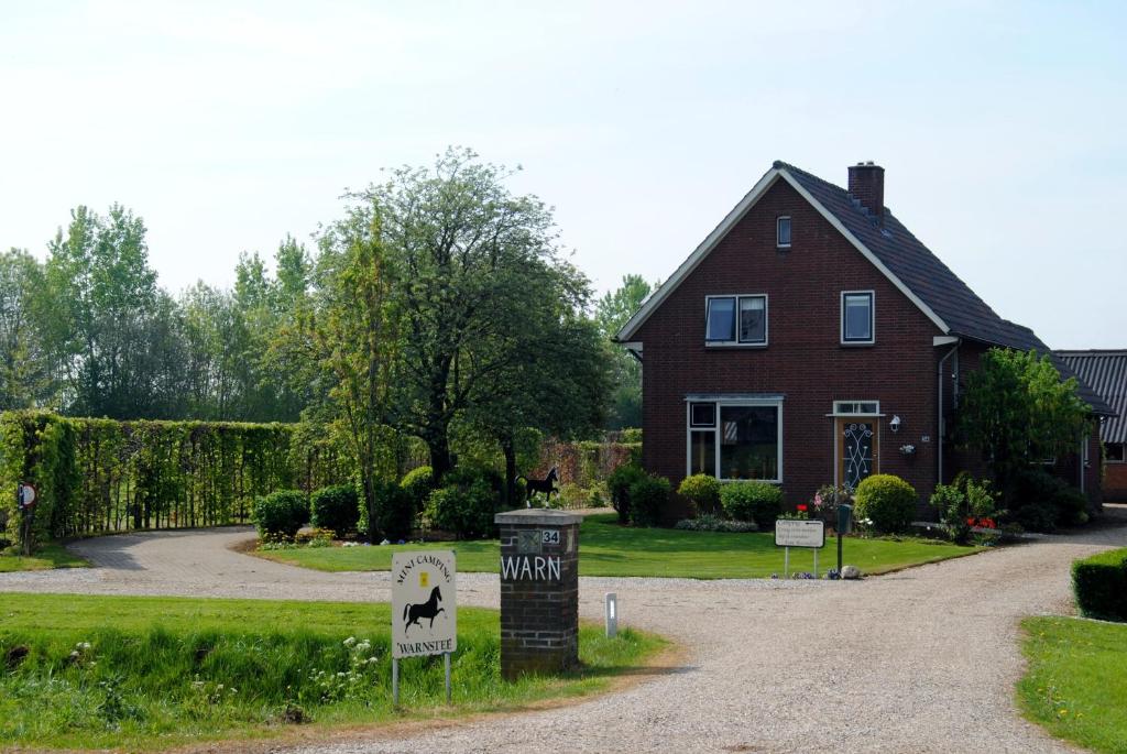 une maison avec un panneau indiquant une cour pour chien dans l'établissement B&B Warnstee, à Wichmond