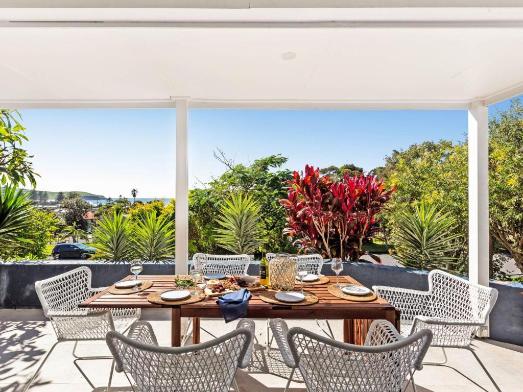 an outdoor dining area with a table and chairs at Blue View Gerringong in Gerringong
