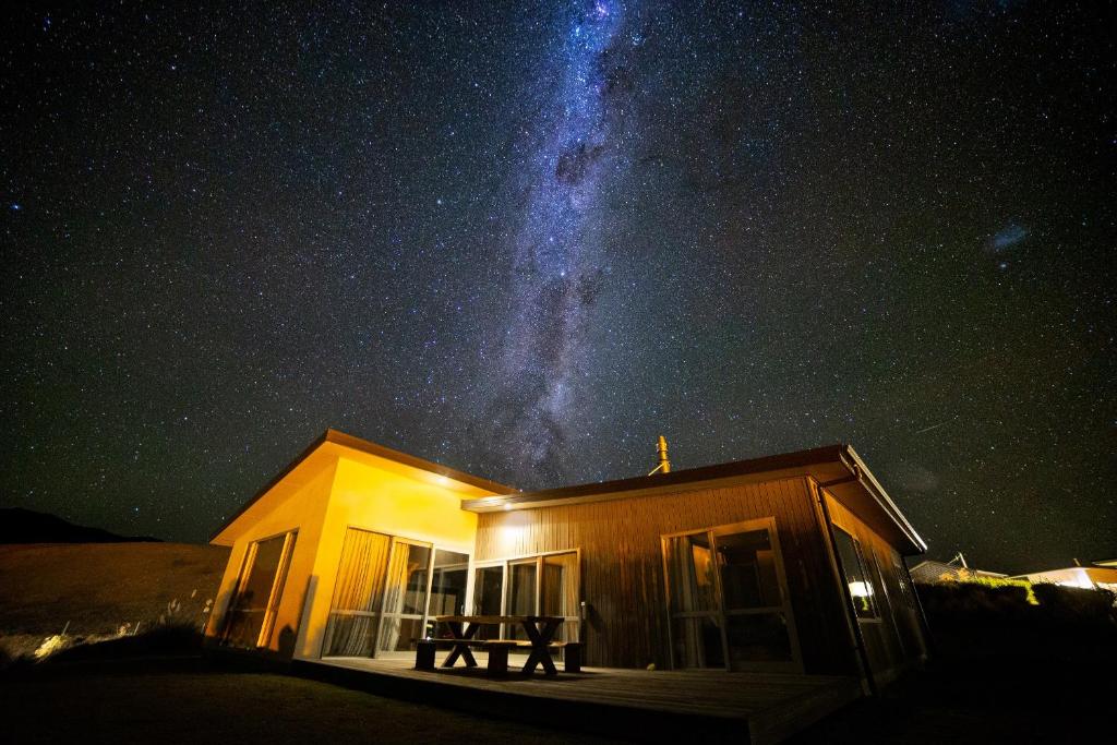 a house with the milky way in the sky at Cedar Stars - Lake Tekapo in Lake Tekapo