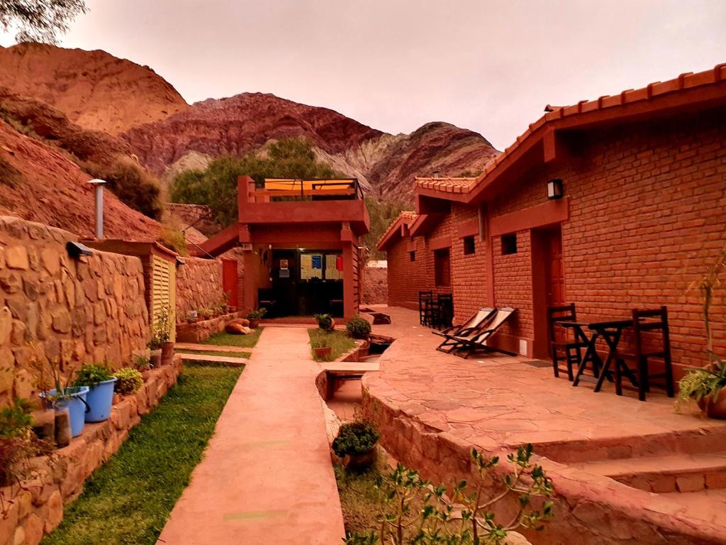 un patio de un edificio con montañas al fondo en La Valentina en Purmamarca