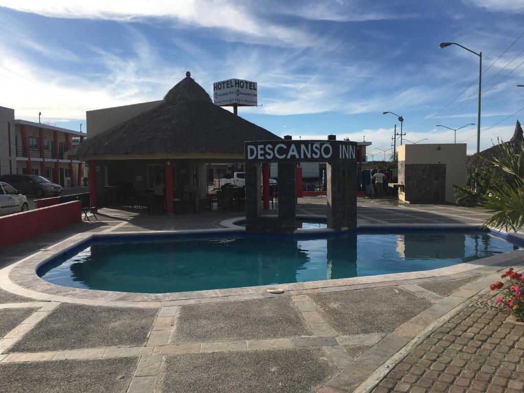 a swimming pool in front of a gas station at El Descanso Inn in Mazatlán