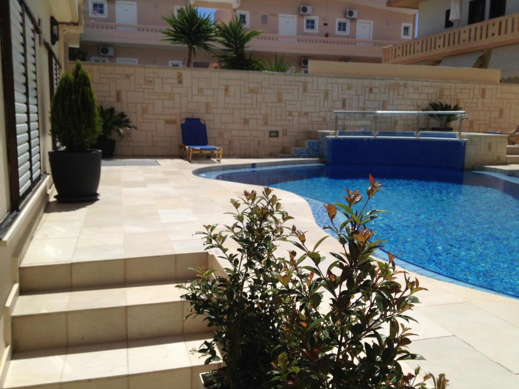 uma piscina no meio de um edifício em Angelica Studios and Apartments em Agia Marina Nea Kydonias
