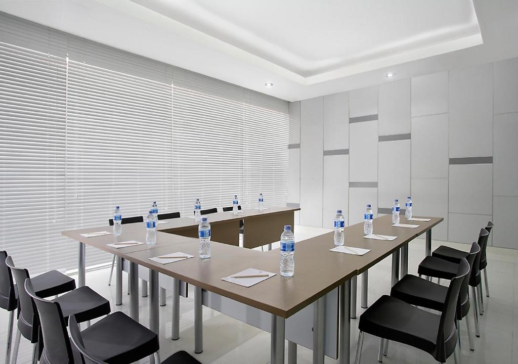 a group of tables and chairs with water bottles on them at Amaris Hotel Juanda in Jakarta