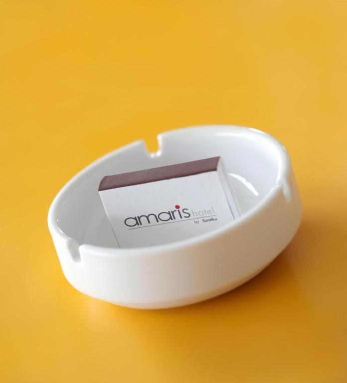 a small white bowl with a card in it at Amaris Hotel Juanda in Jakarta