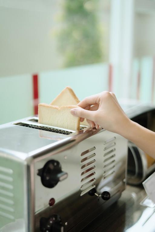 a person is putting a brush into a toaster at Amaris Hotel Juanda in Jakarta