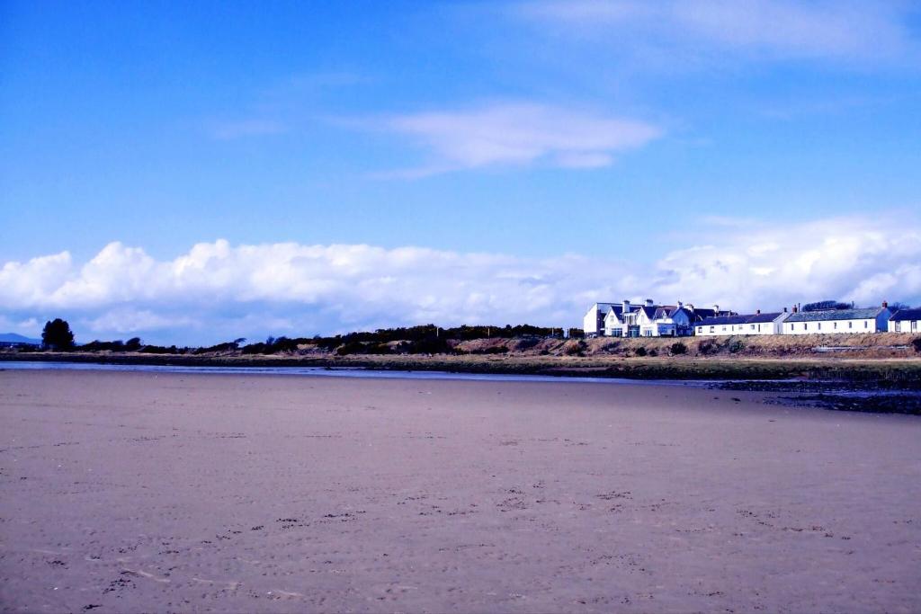 a view of a beach with buildings in the background at Scottish Border Powfoot Dumfries in Annan