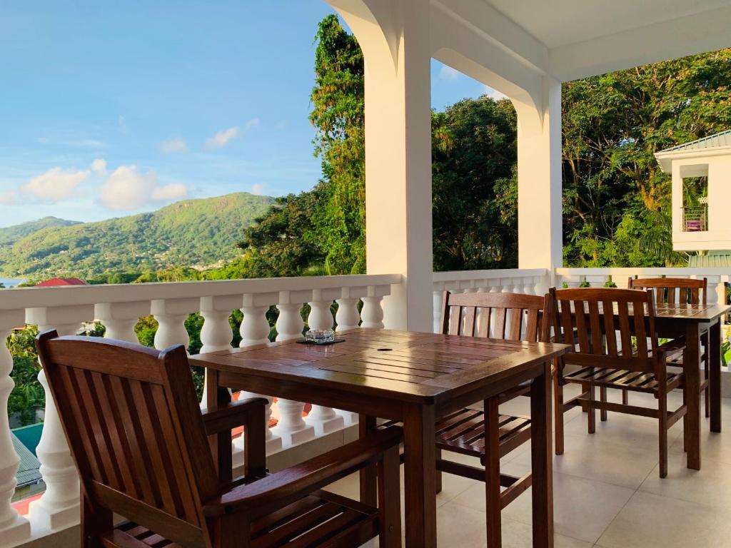 a dining room with a table and chairs on a balcony at Oceanic View Apartments in Beau Vallon