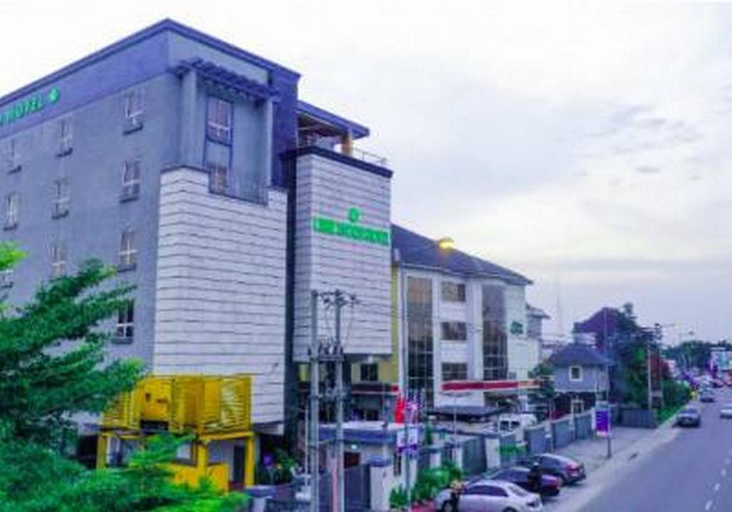 a building on the side of a street with cars at Room in Apartment - Limewood Hotel 5 Star Port Hotel in Port Harcourt