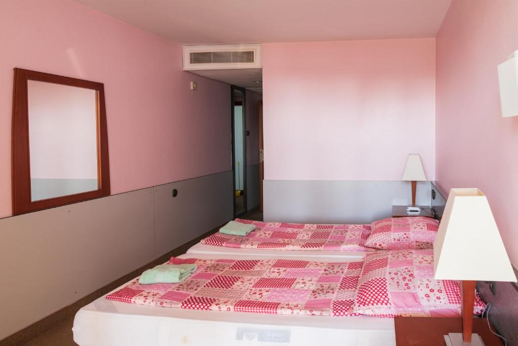 A bed or beds in a room at Négy Évszak Panziò