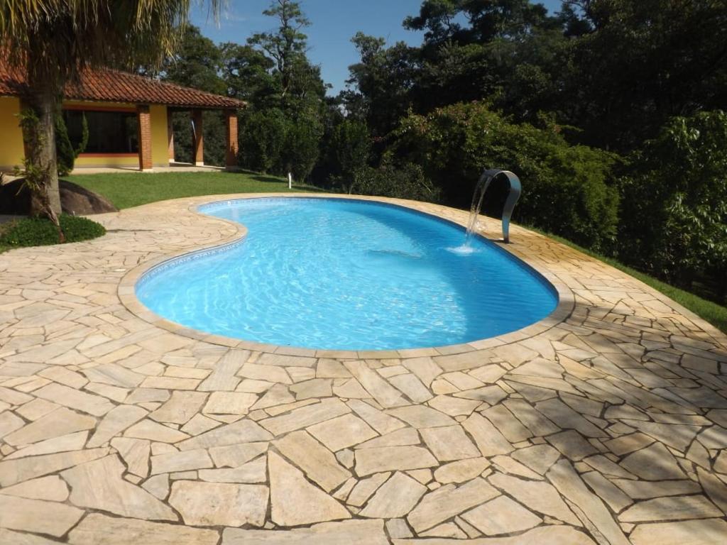 uma pequena piscina com uma fonte de água num quintal em Sitio do Tonetti em Mairiporã