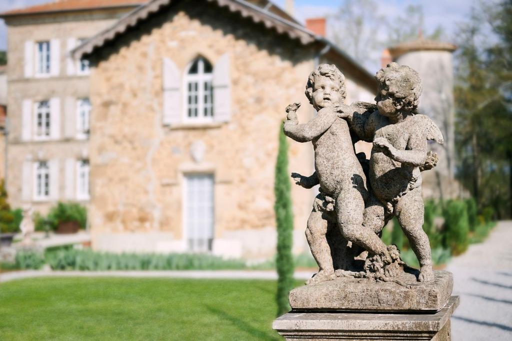 une statue d'un garçon et d'une fille devant une maison dans l'établissement Gites de charme à la campagne, à Lemps