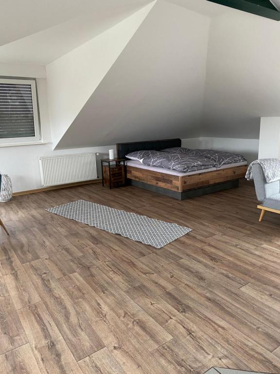 a bedroom with a bed and a wooden floor at Appartement 7 in Hilter in Hilter am Teutoburger Wald