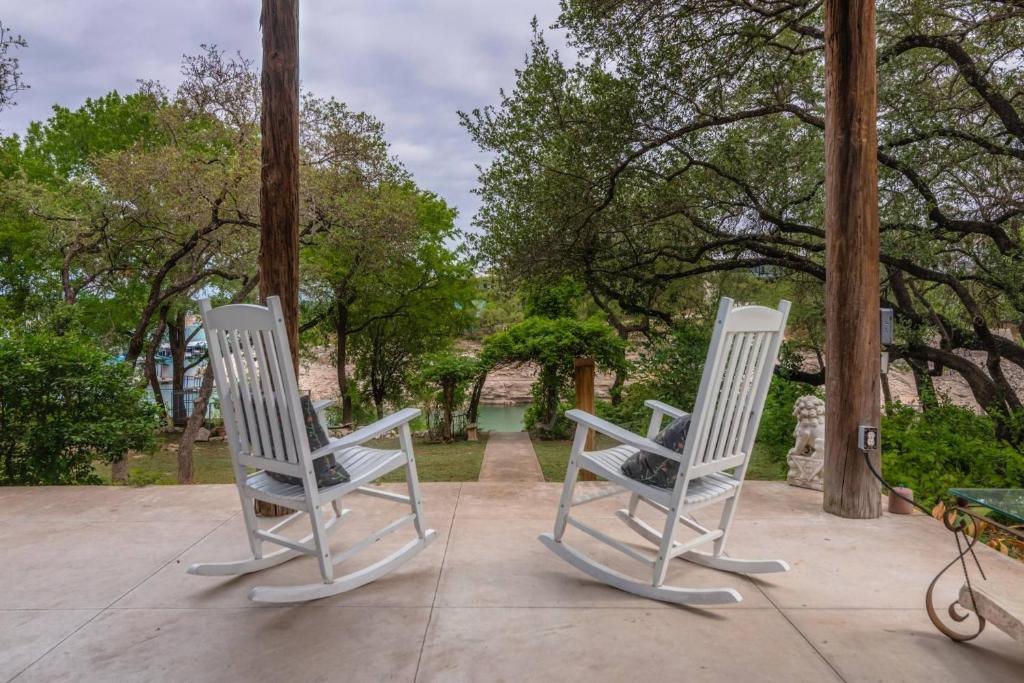 twee witte schommelstoelen op een patio bij The Nest on Lake Travis in Buffalo Gap