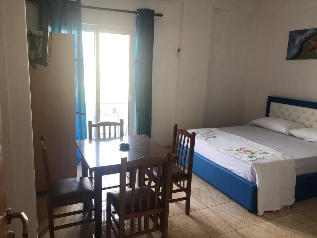 a bedroom with a bed and a table and chairs at Romantika in Shëngjin