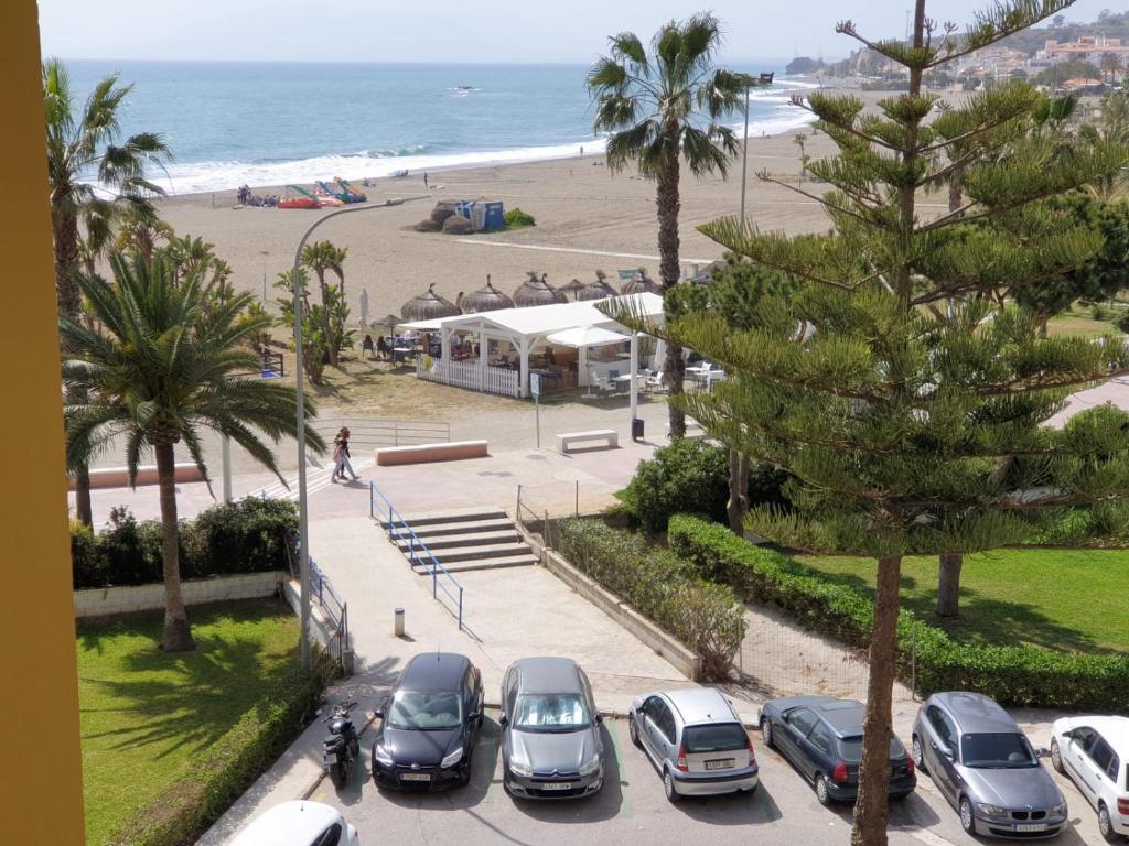 - un groupe de voitures garées dans un parking près de la plage dans l'établissement Bonito apartamento en primera línea de playa, à Cala del Moral