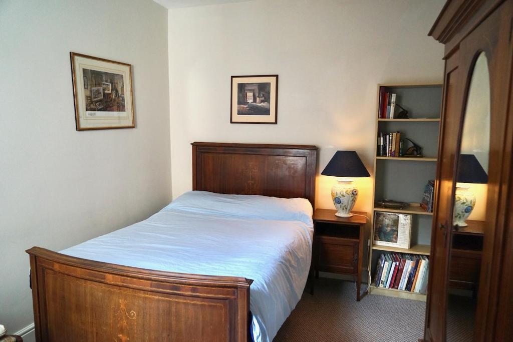 a bedroom with a bed and a book shelf at Tottenham Stadium double room in London
