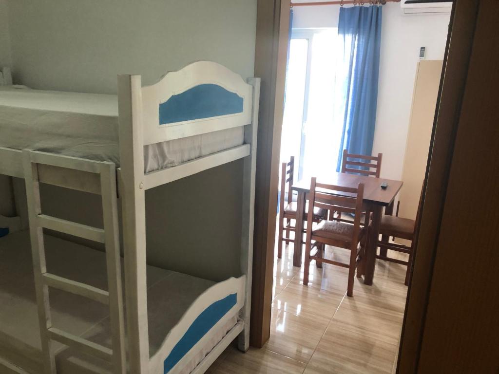 a bedroom with a bunk bed and a dining room at Romantika in Shëngjin