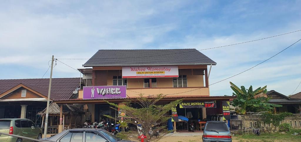 a building with cars parked in front of it at OYO 90252 Penginapan Wahee in Kuala Terengganu