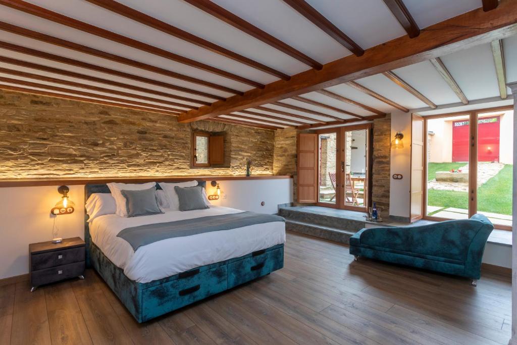 a bedroom with a large bed and a stone wall at Araucaria House in Barreiros